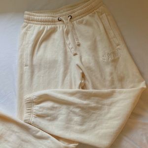 cream colored sweatpants w ‘saint’ embroidery